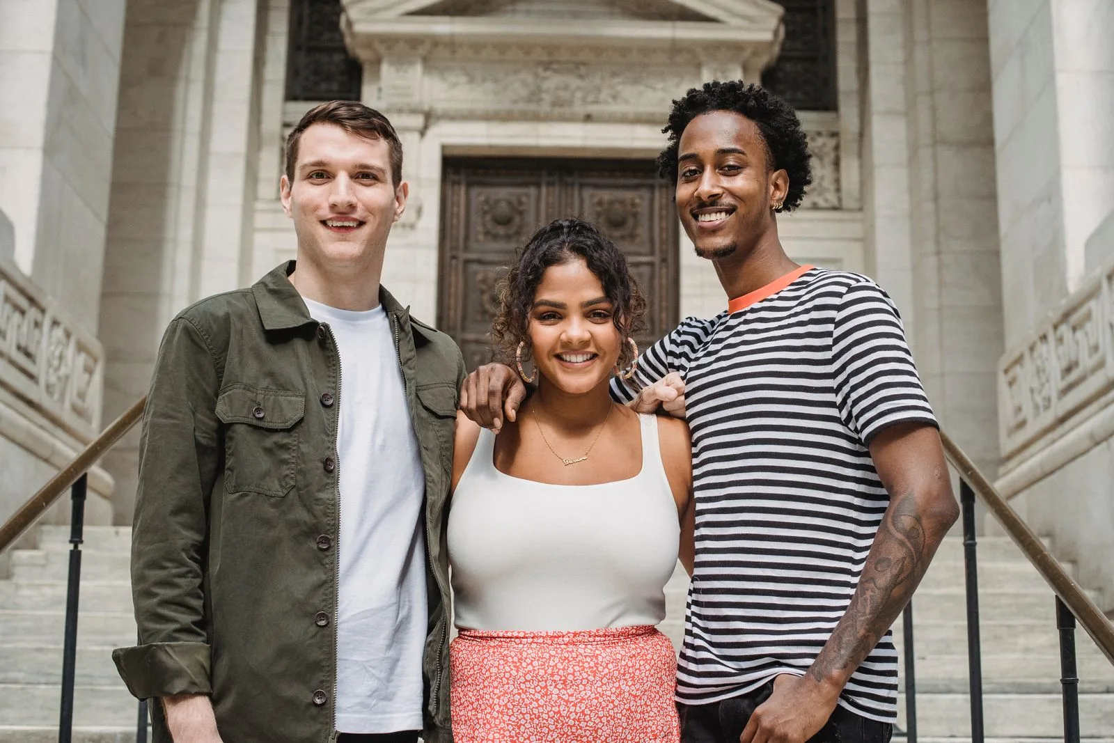 Tres estudiantes jóvenes sonriendo con sus cuadernos